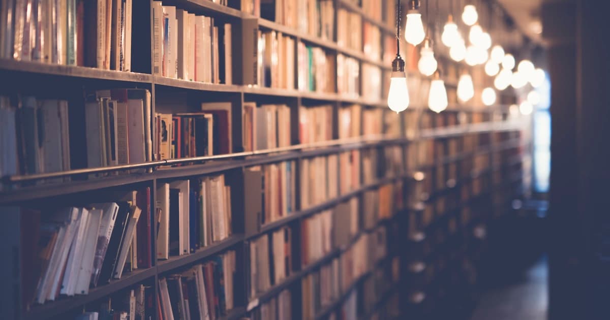 Rows of books in an old library — forgotten inventors who shaped the modern world