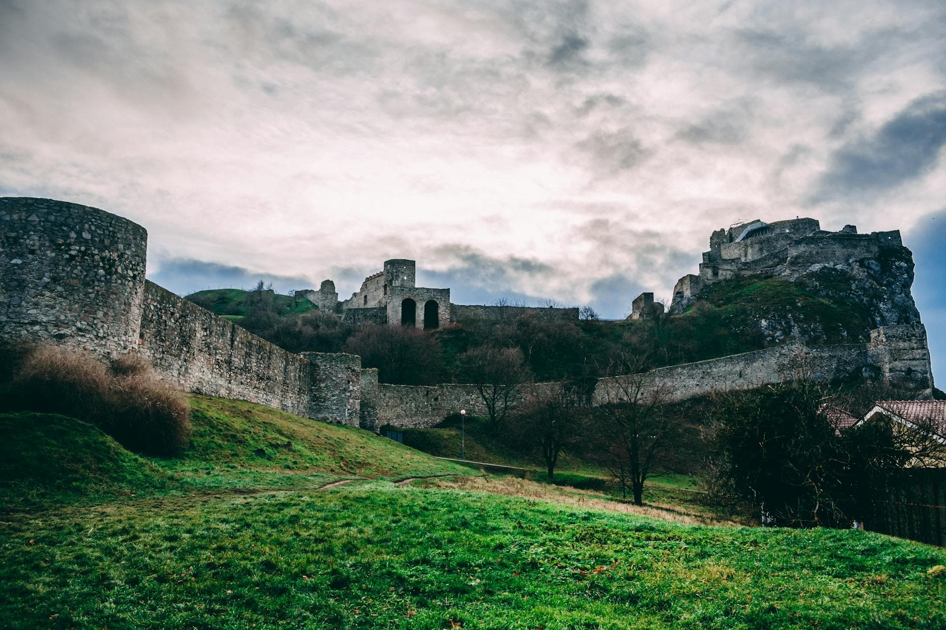 How the Black Death Accidentally Built Modern Europe — Discover the ancient Devín Castle in Slovakia, captured under a dramatic cloudy sky.
